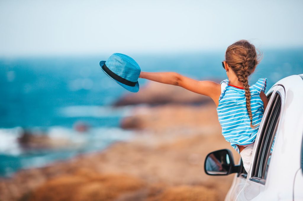 Petite fille qui part en vacances avec ses parents en voiture